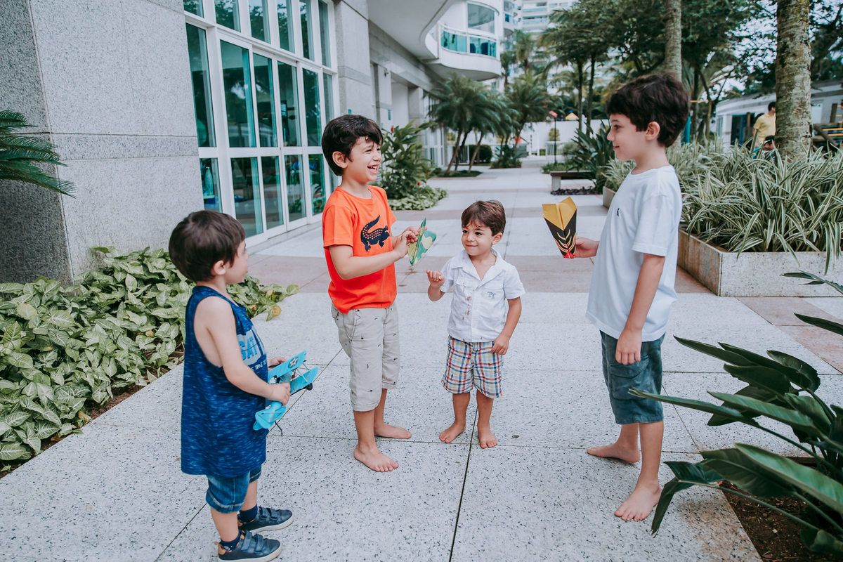 fotografia de quatro meninos conversando e sorrindo no patio do condominio
