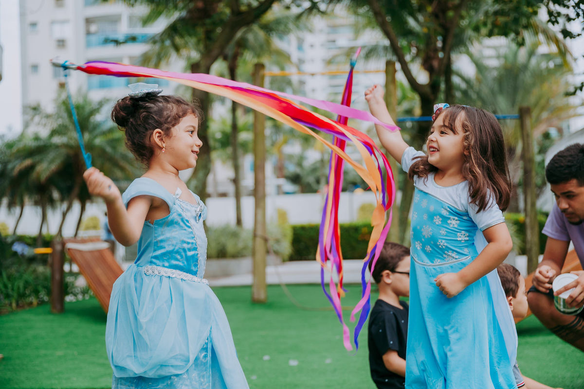 fotografia de meninas vestidas de princesa brincando com fitas