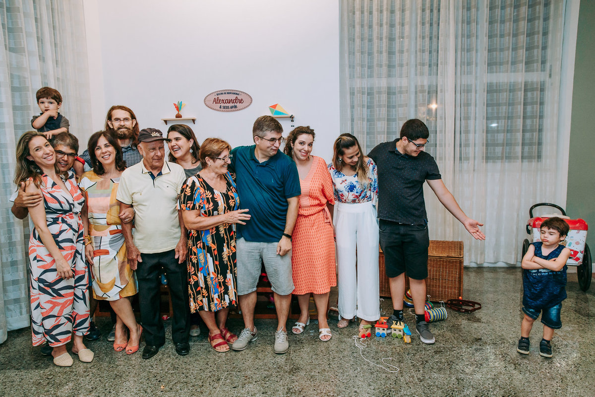 fotografia de toda a familia posando para a foto enquanto que o aniversariante se recusa