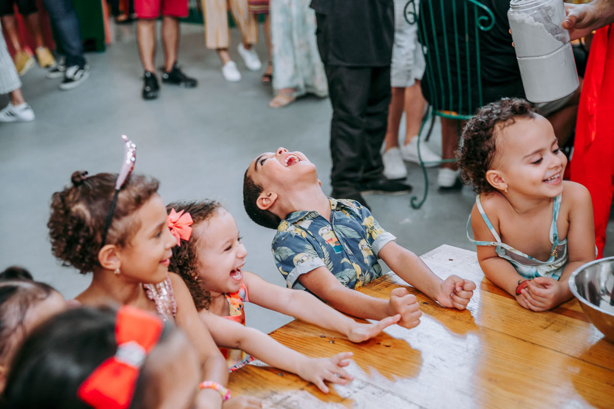 menino e menina socam a mesa enquanto gargalham durante recreação na casa de festas vilarejo na barra da tijuca no rj