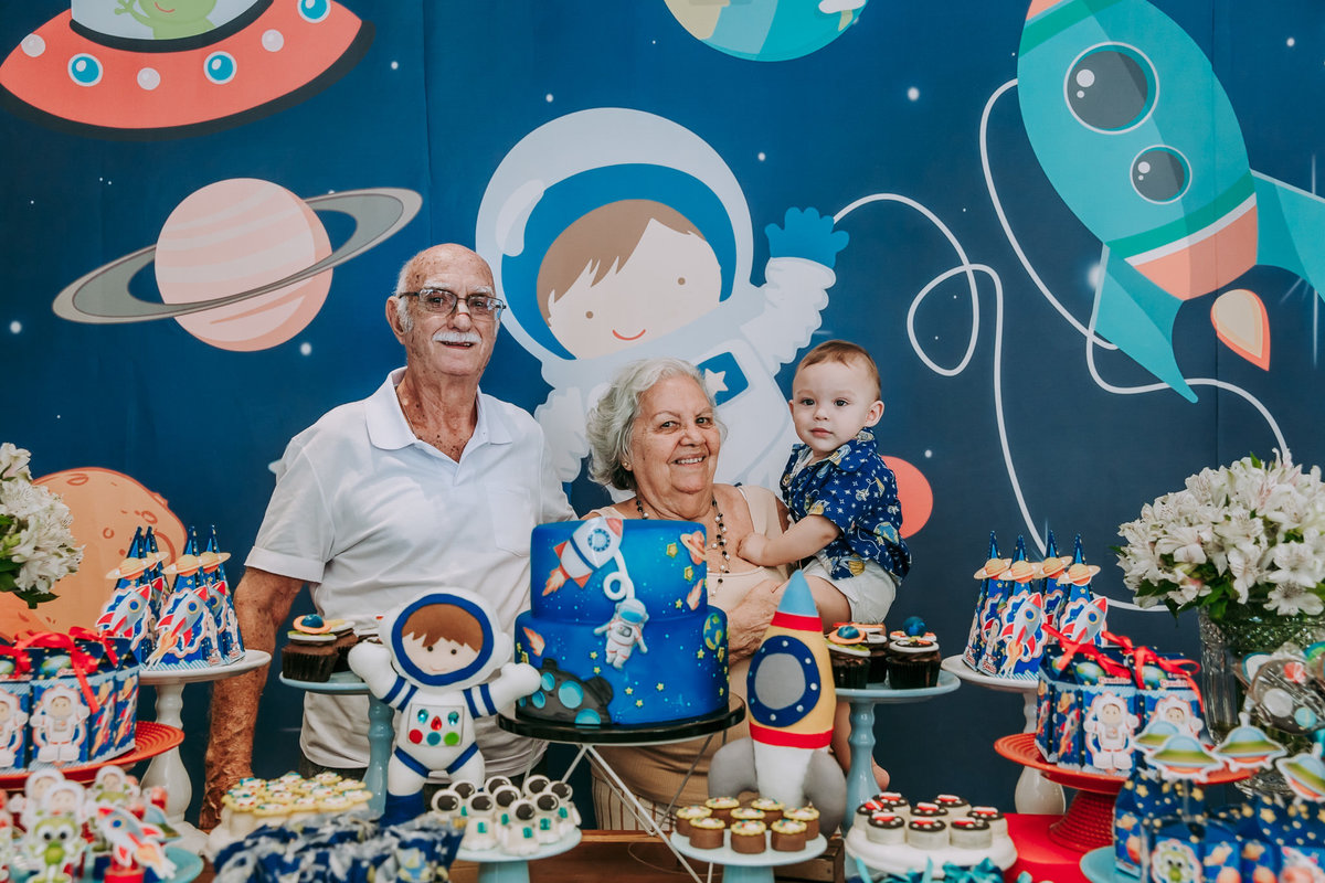 aniversariante com avós na mesa do bolo