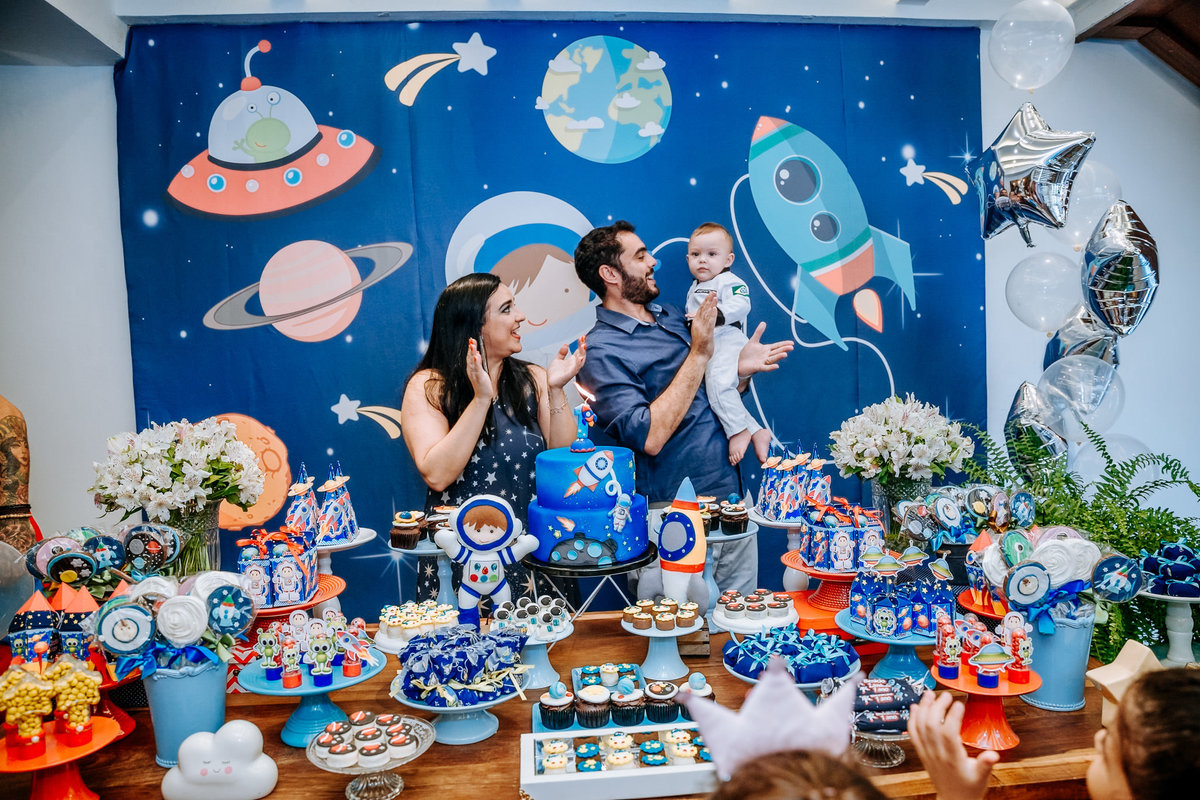 familia na hora do parabéns em aniversário com tema galático