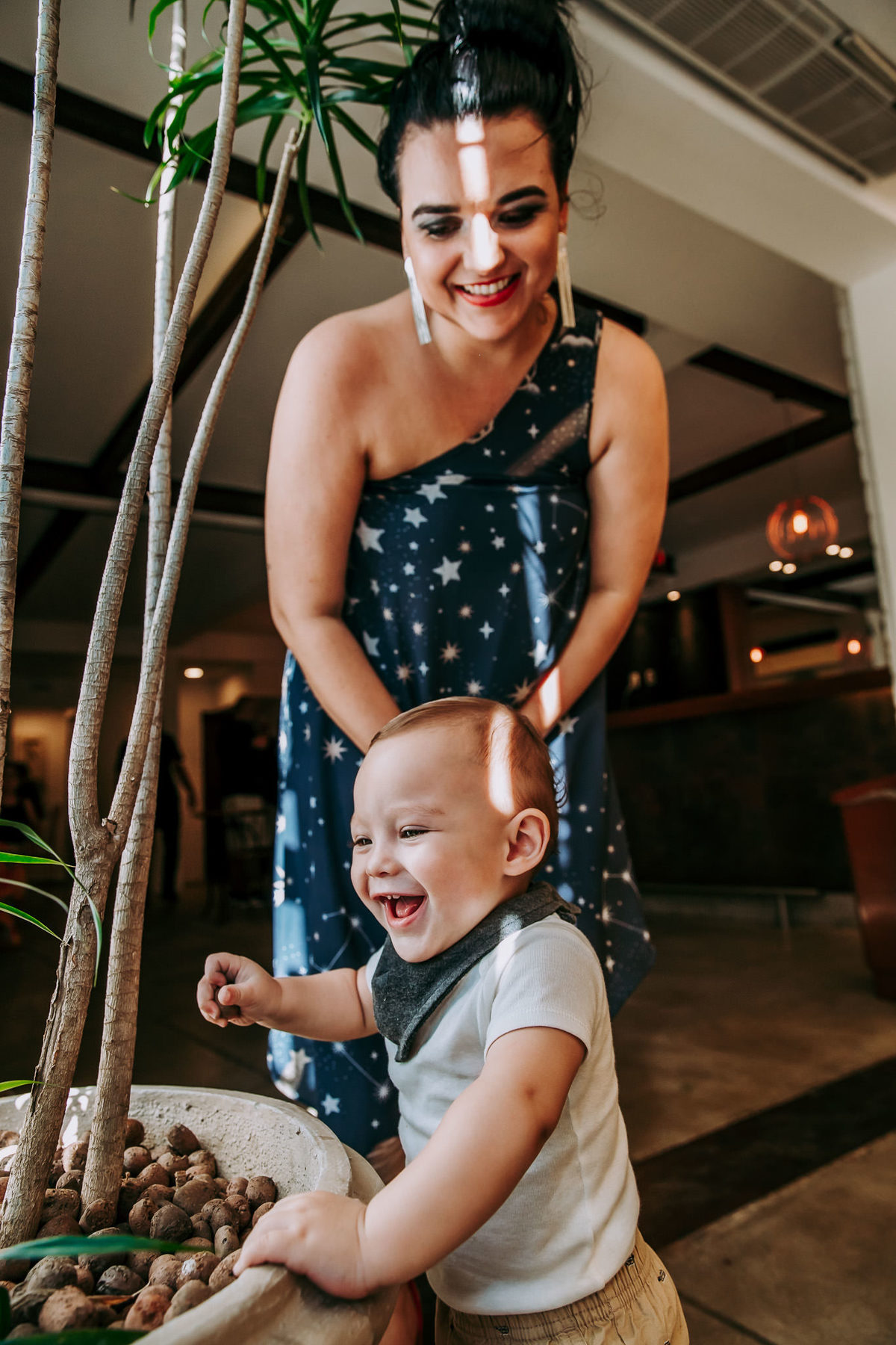 Criança brincando com pedrinhas de vaso de planta em são de festas da casa de festas volarejo na barra da tijuca rj