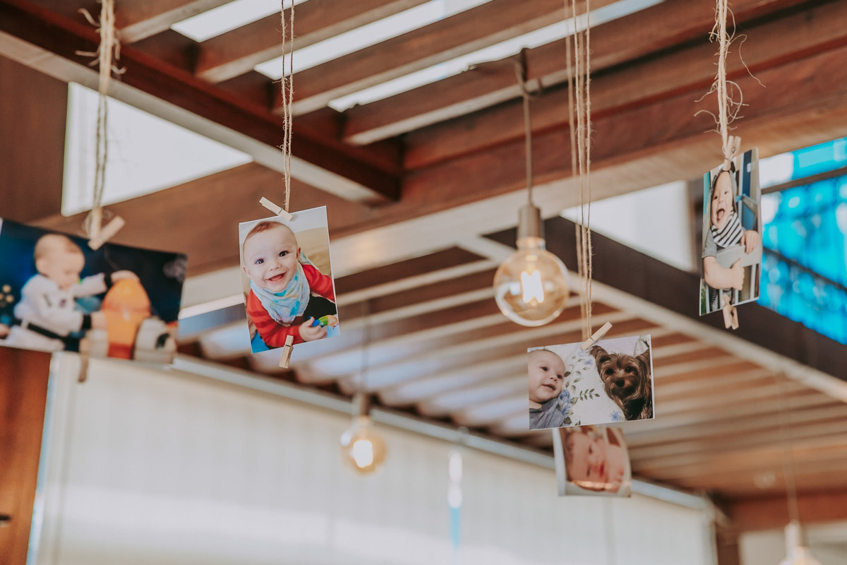 Detalhes da decoração com fotos do aniversariante penduradas no teto com fios de sisau
