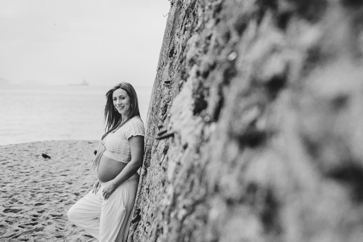foto preto e branco de getante encostada em parede de pedra na praia vermelha no rj