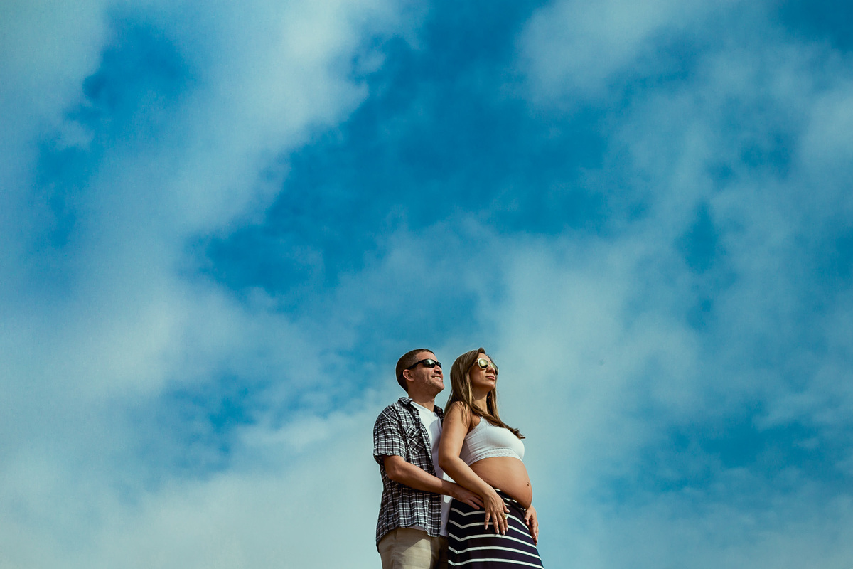 foto de casal gestante com ceu azul ao fundo