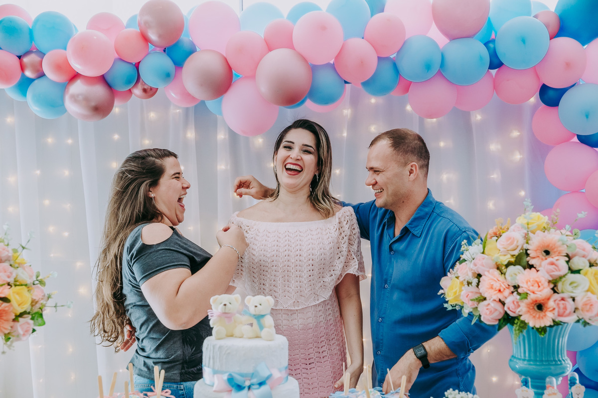 amiga de casal gestante interagem alegremente na mesa do bolo do cha revelacao