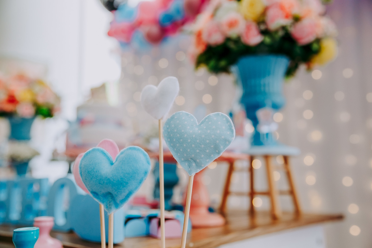 coracoes em feltro azuis presos em palito de churrasco fazendo parte da decoracao do cha revelacao