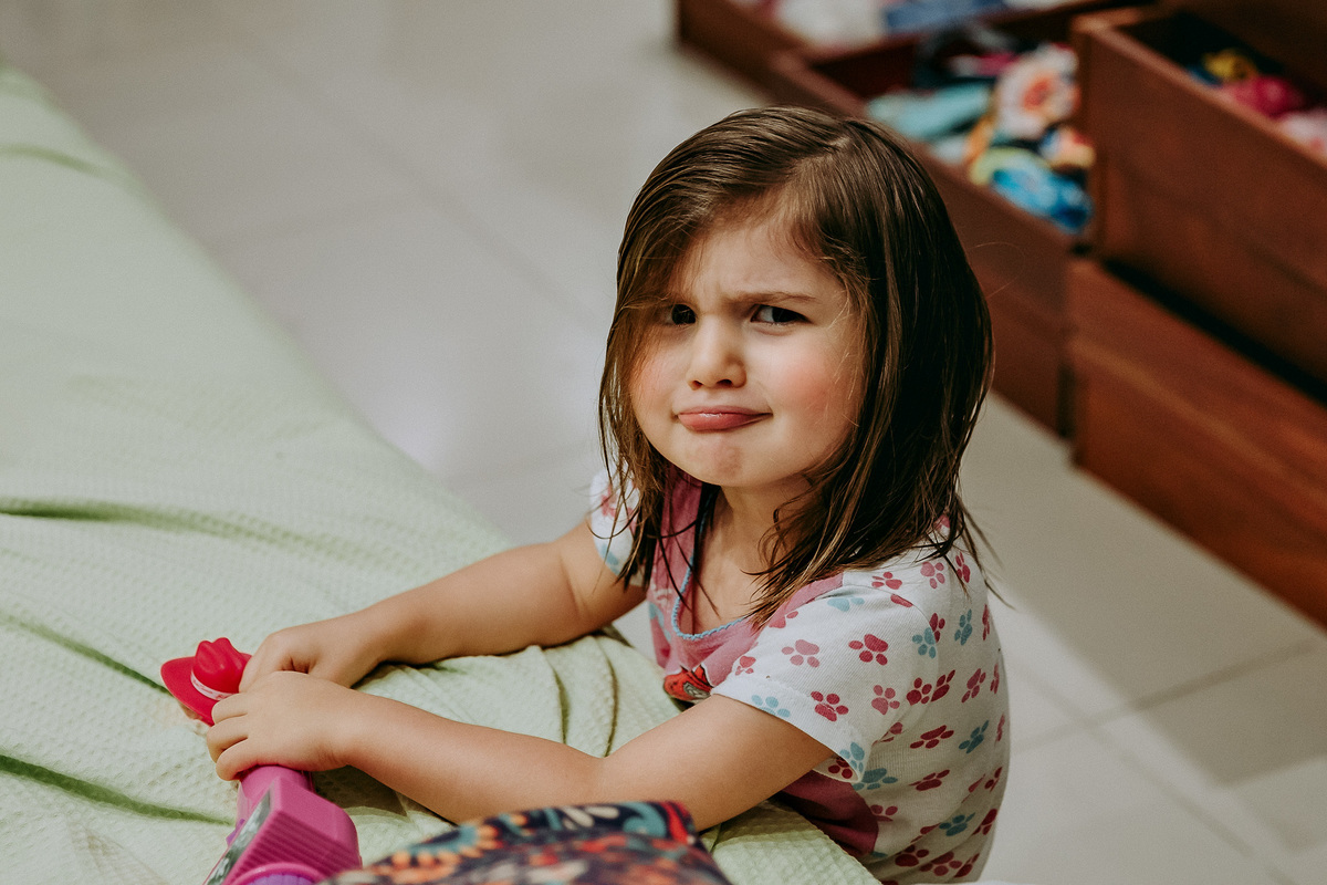 menina brincando em casa e fazendo careta para camera