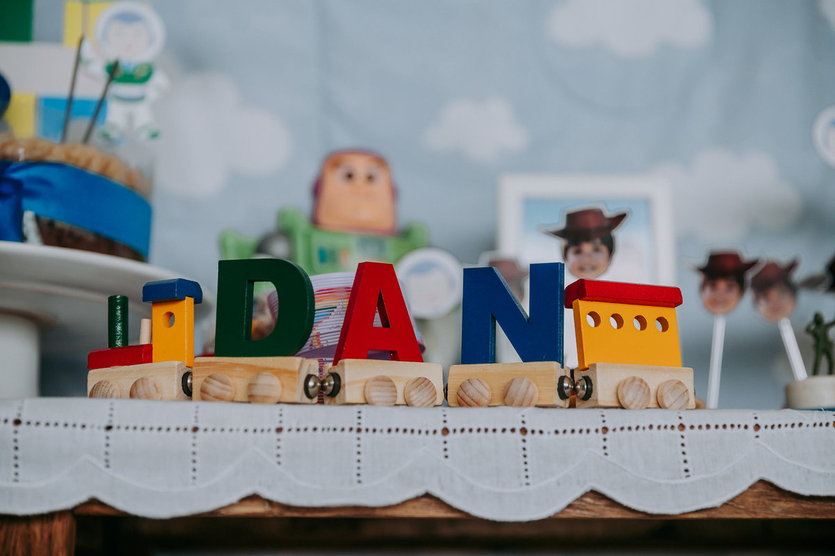 trenzinho de madeira com nome do aniversariante em mesa de bolo do toy story