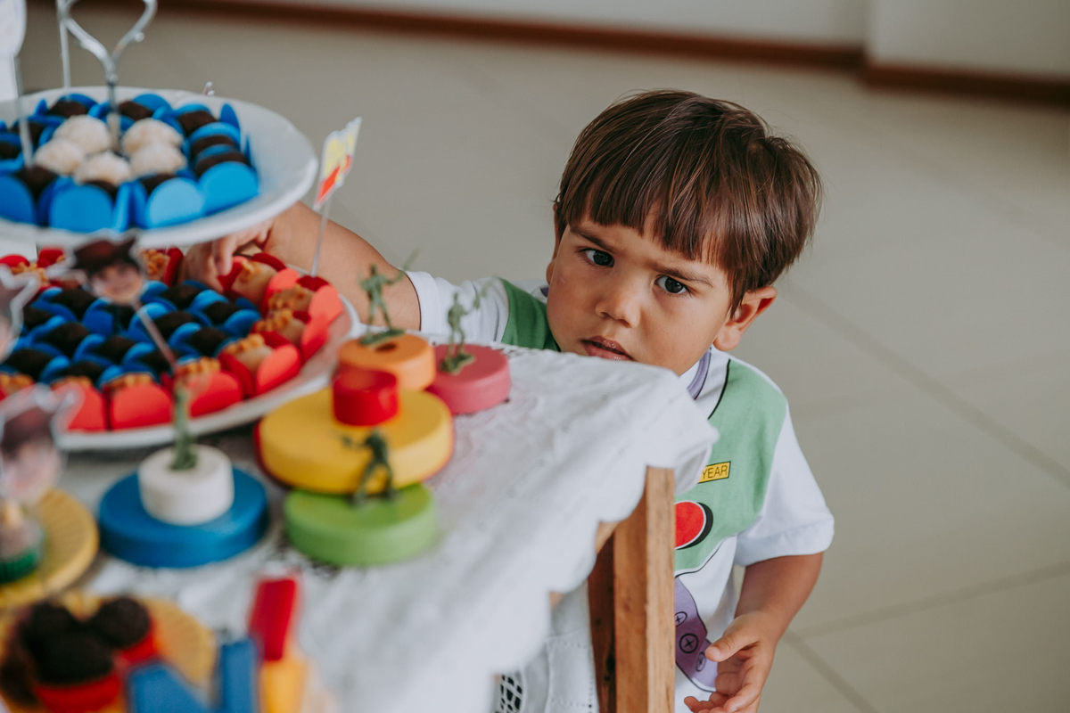 aniversariante de 2 anos roubando docinho da mesa e olhando enfurecido pra foto