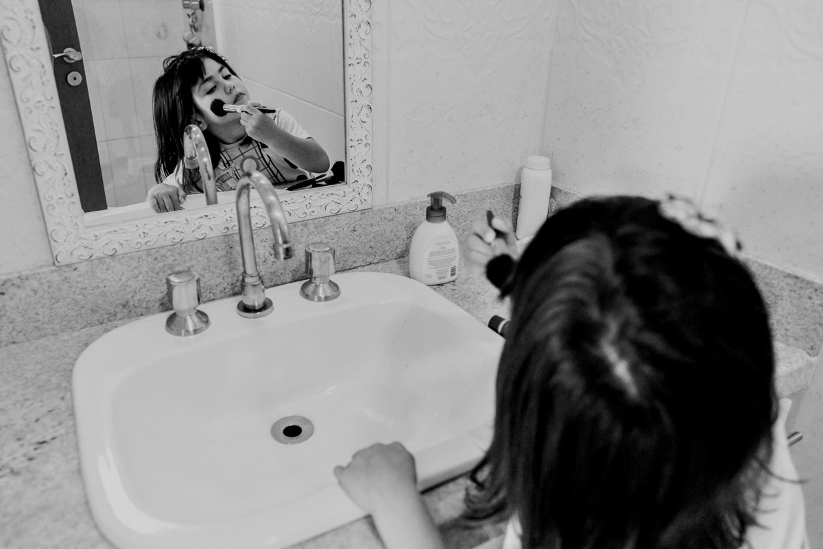 menina de 4 anos se pintando em frente ao espelho