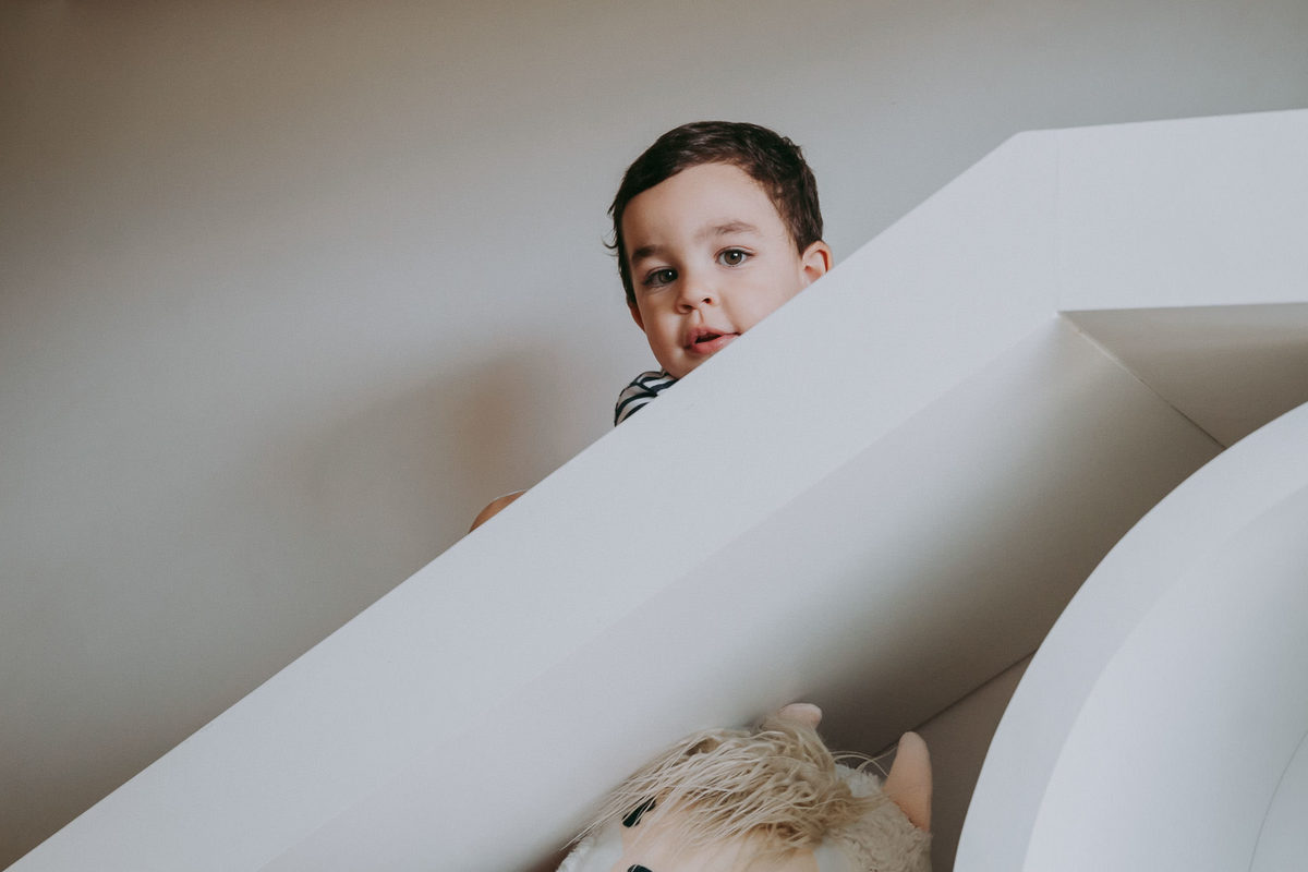 criança descendo do escorrega e olhando pra camera fotografica
