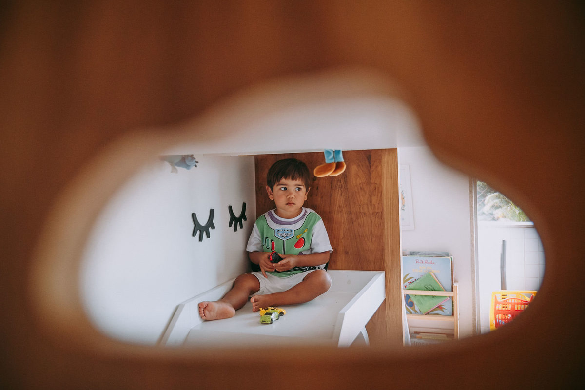 foto de menino vestido de buzz lightyear sentado em escorrega de cama de seu quarto 