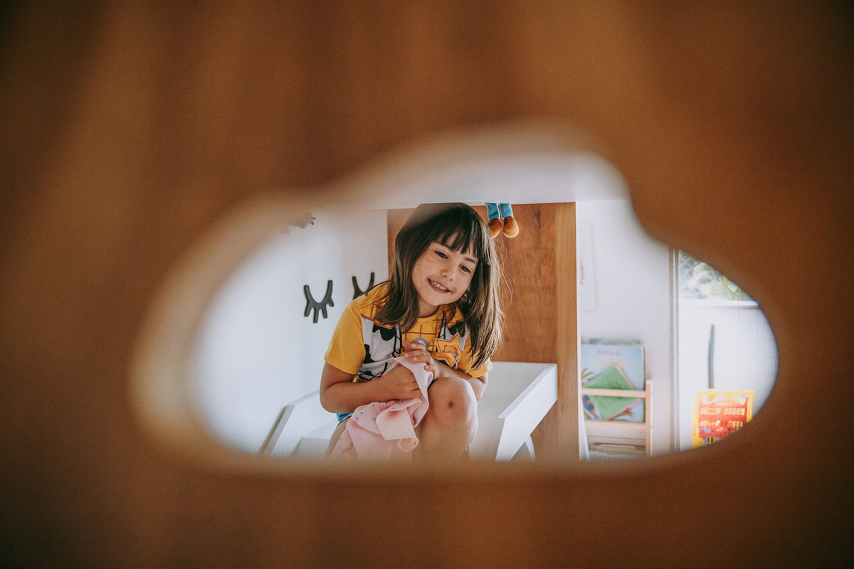 foto de menina emoldurada por nuvem sentada em escorrega da cama de seu quarto