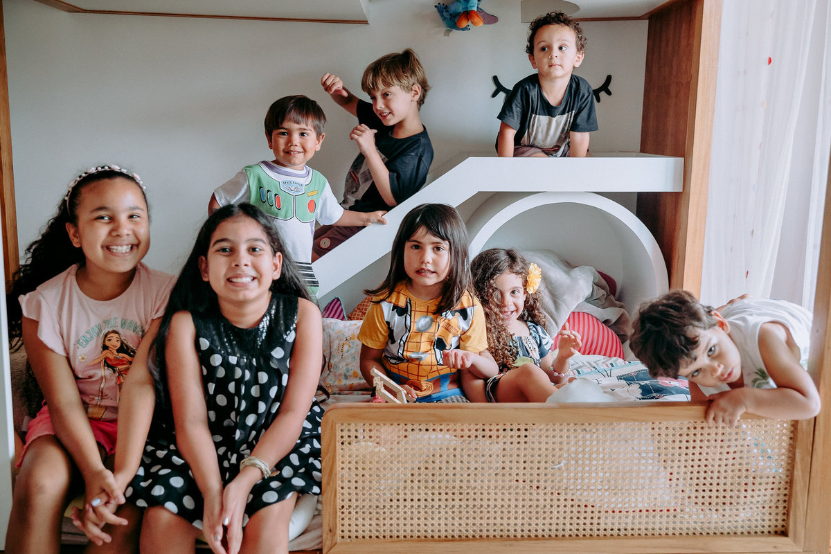 oito crianças sentadas em cama posando para foto