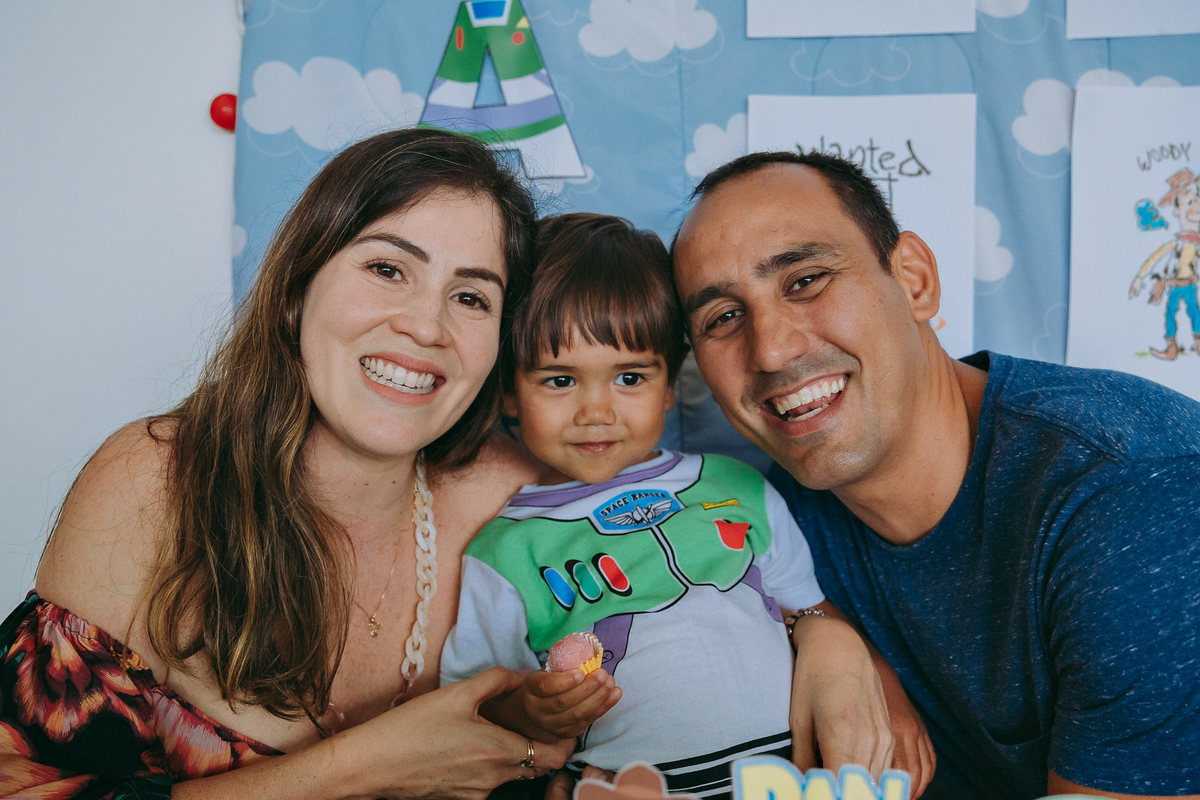 mae, filho e pai posando para foto de aniversario em casa
