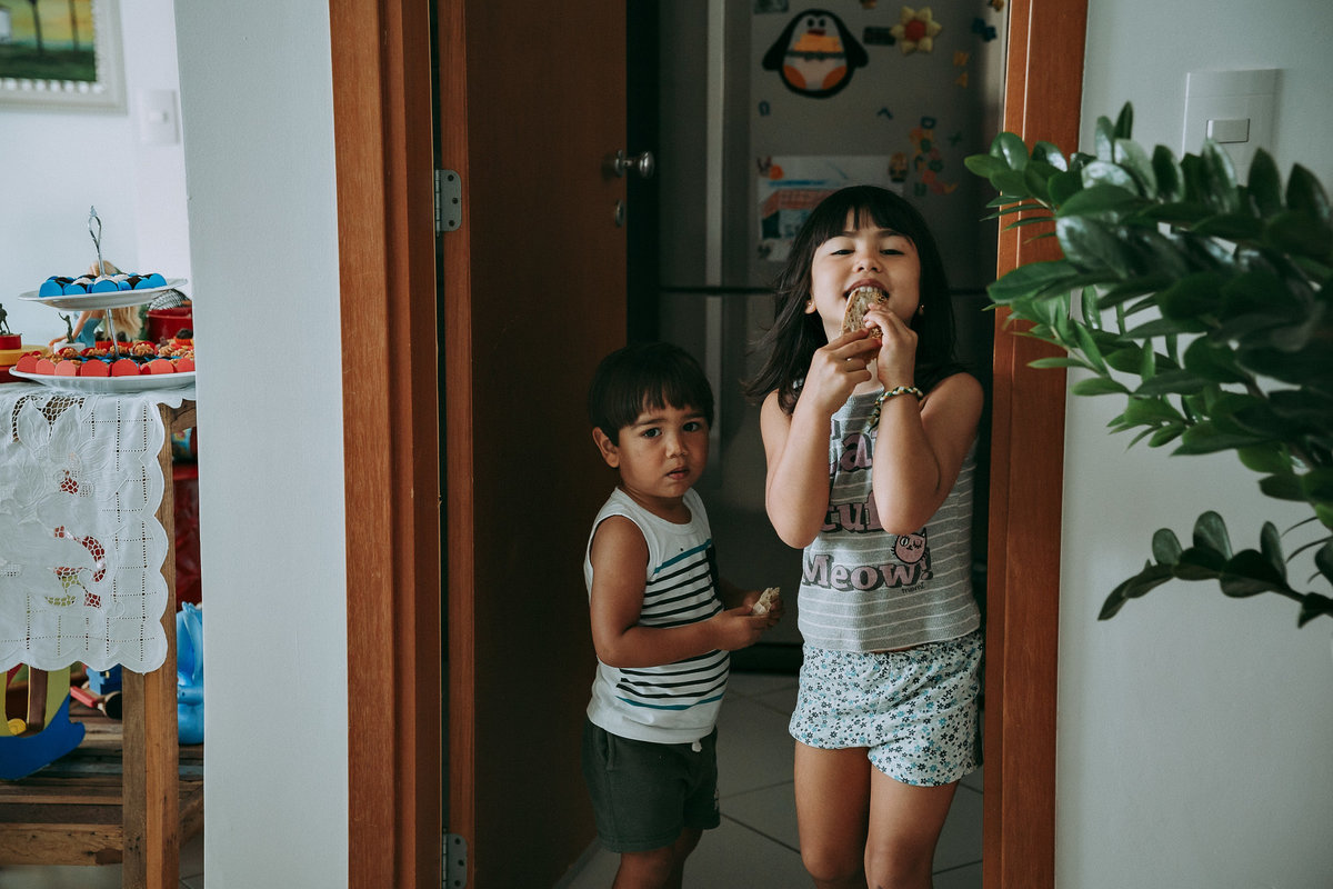 foto documental de irmãos comendo pão em sua casa