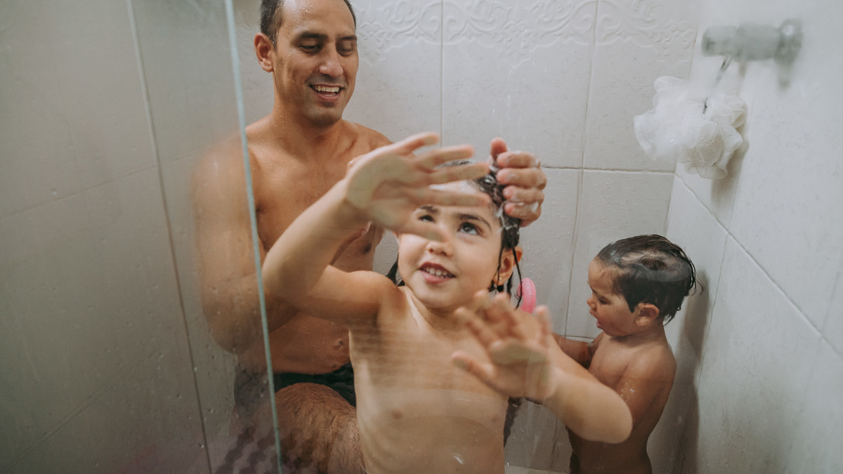 pai dando banho em seus dois filhos