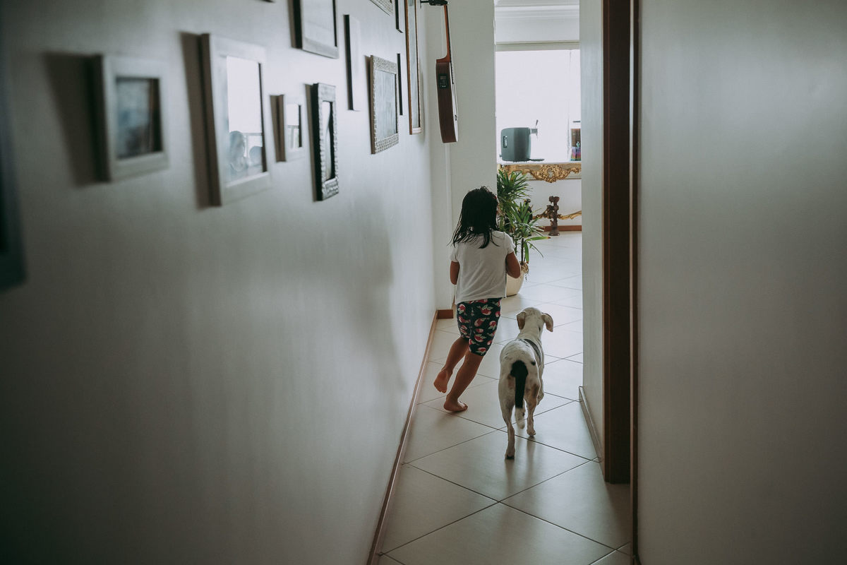 menina de 4 anos correndo com cachorro pelo corredor do aprtamento no recreio dos bandeirantes