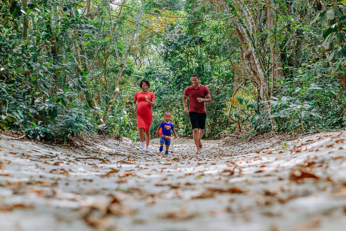 Familia composta por mae gestante filho e pai correndo no parque chico mendes no rj