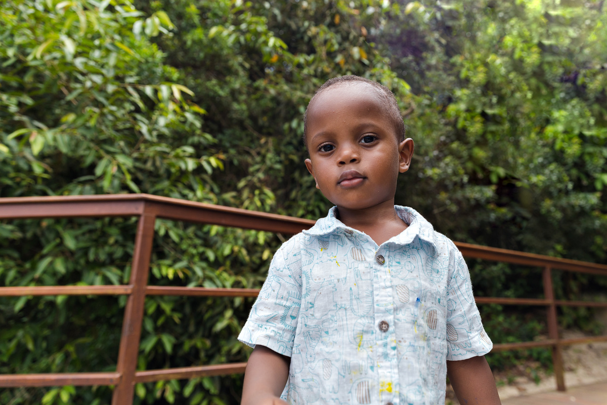 menino de dois anos olha serio para a camera enquanto é fotografado