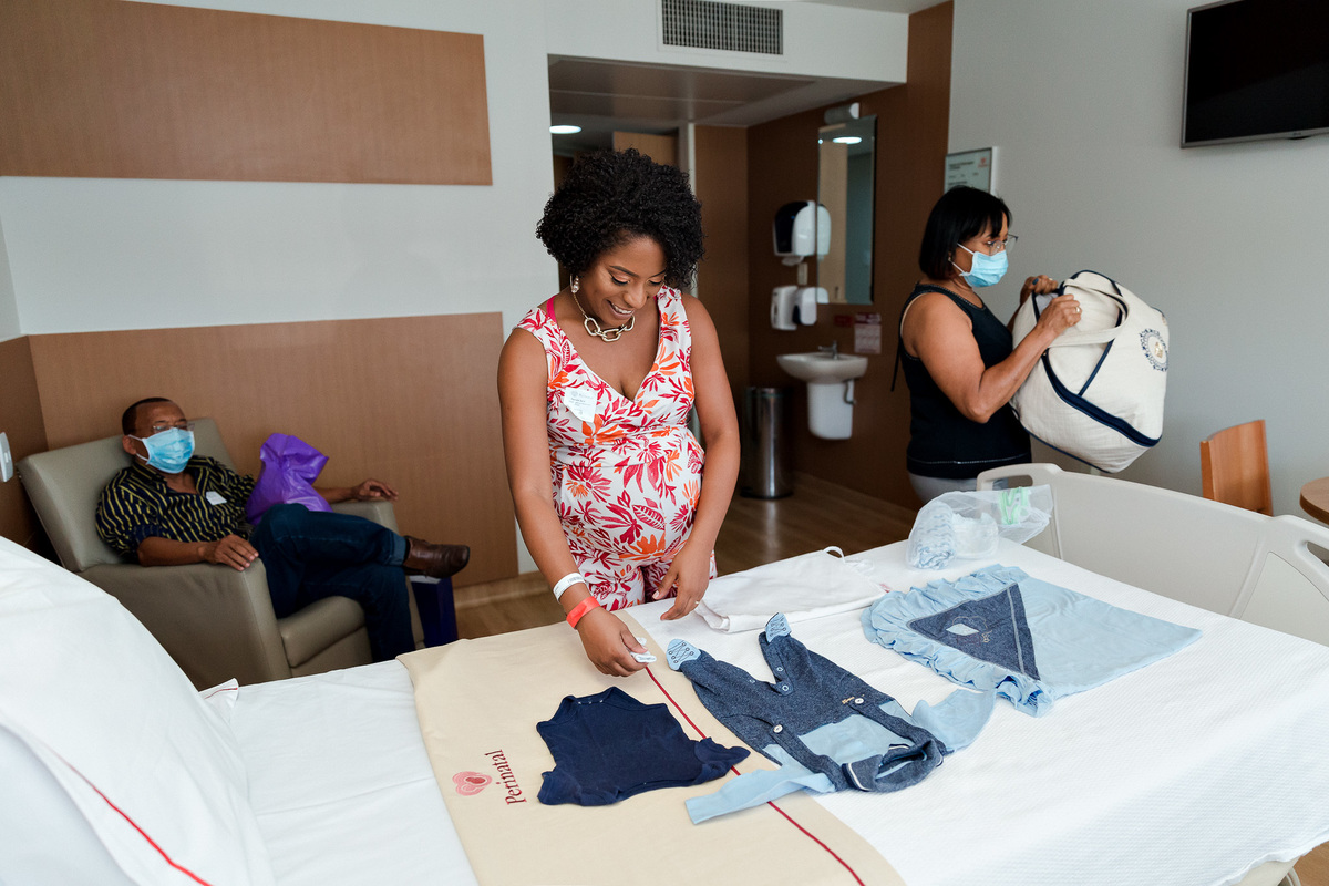 mãe gestante arrumando as roupas de seu filho
