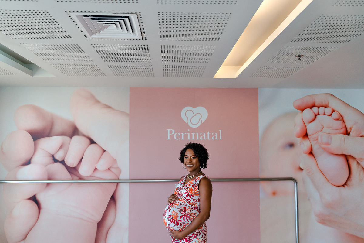 foto de gestante de meio corpo em frente ao painel da perinatal da barra da tijuca