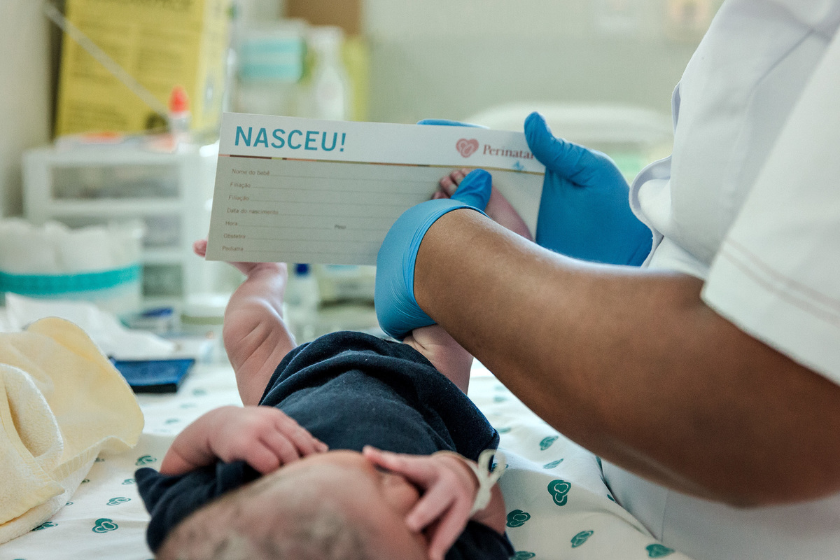 enfermeira coloca a impressao digital de pé do recem nascido em papel escrito nasceu
