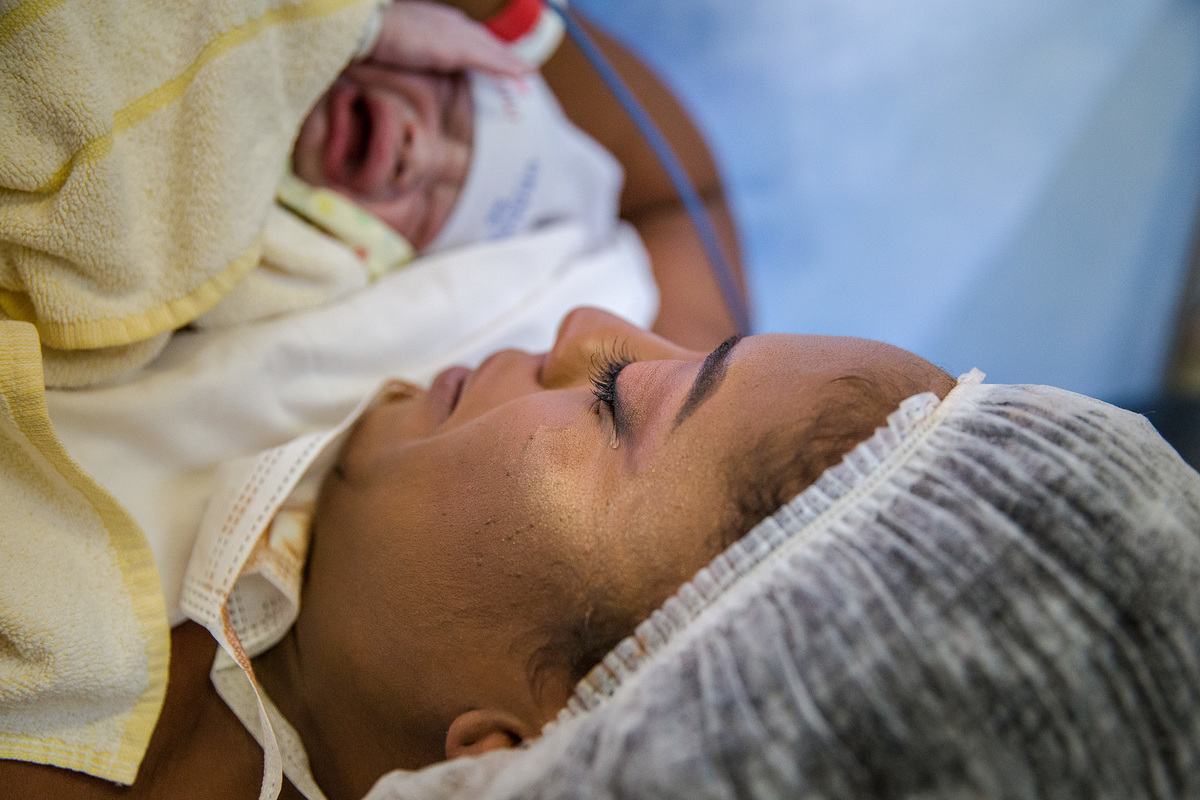 mae emocionada ao pegar seu bebe pela primeira vez.