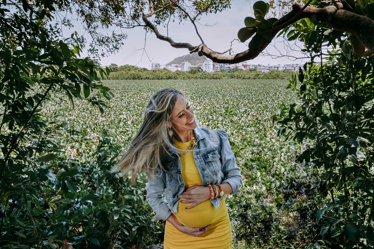 foto de gestante com as maos na barriga e girando a cabeça de um lado para o outro causando movimento dos cabelos