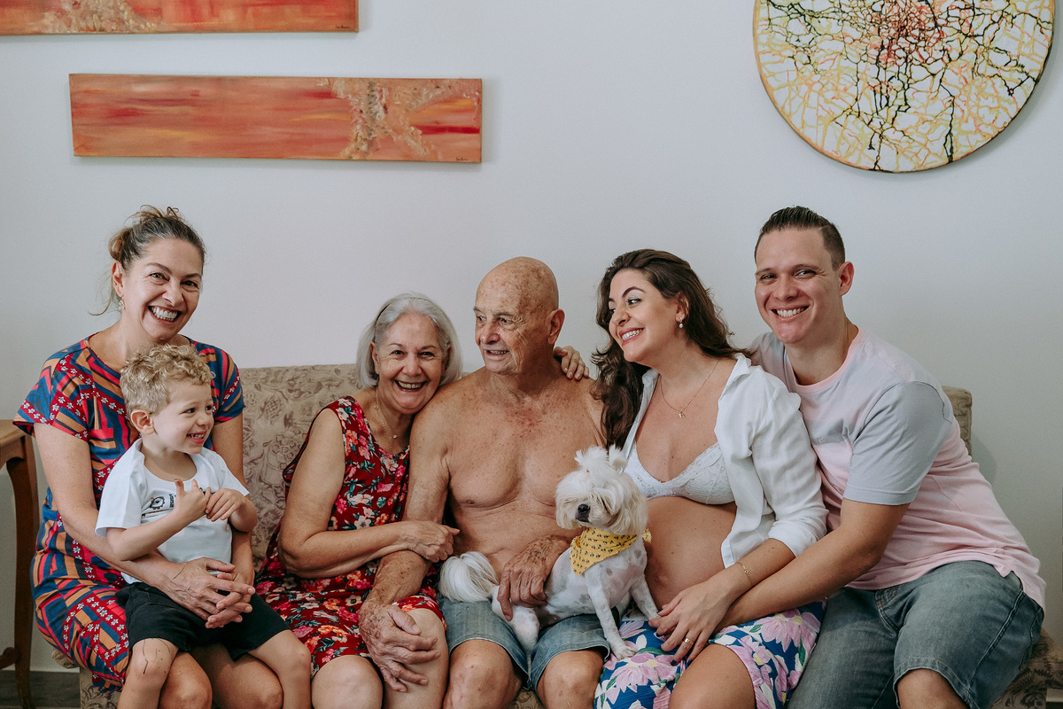familia sentada no sofa acompanhada da cachorrinha
