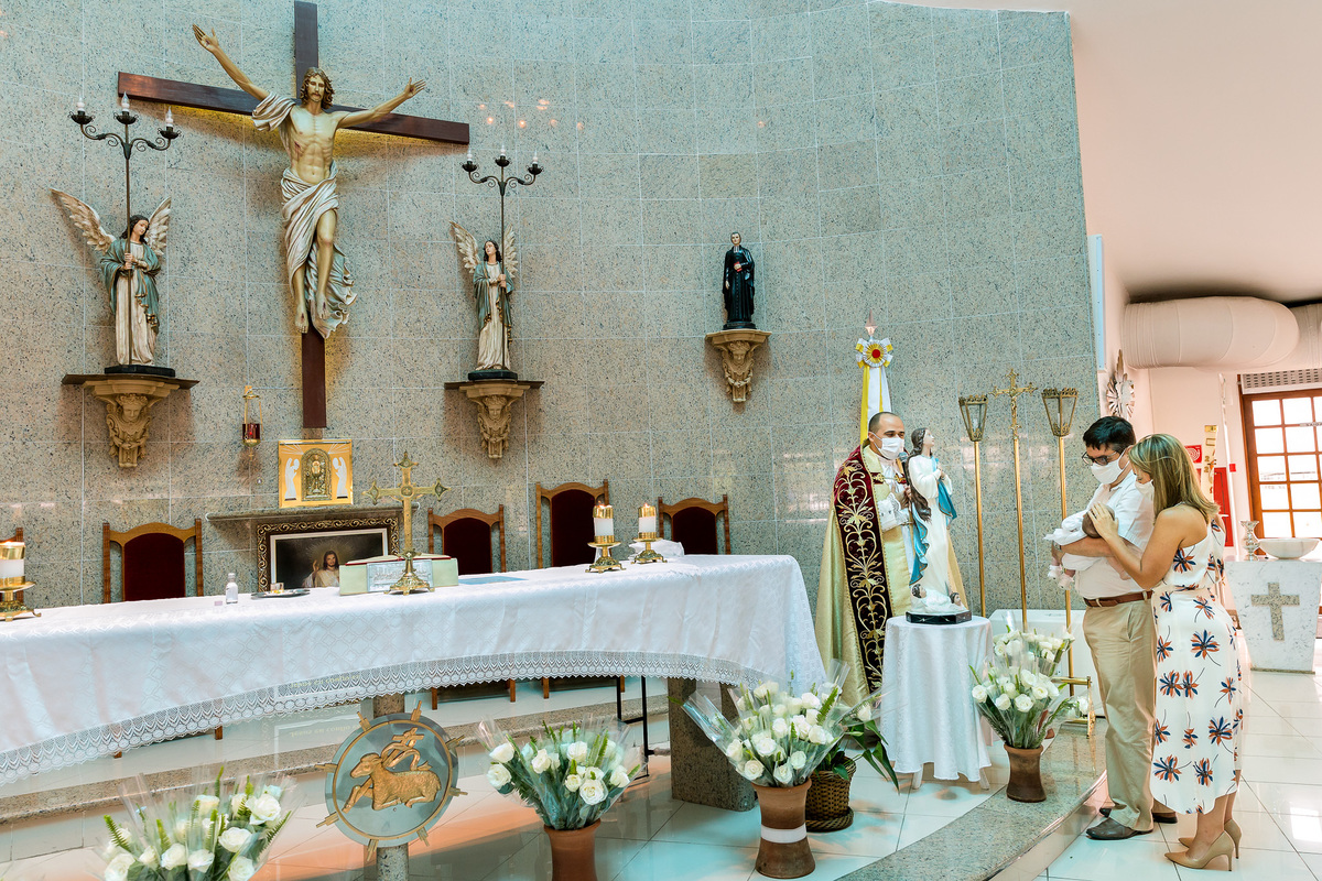 foto de plano geral mostrando o altar da Paróquia São Marcelino de Champagnat e os padrinhos apresentando a criança a nossa senha da conmceiçao