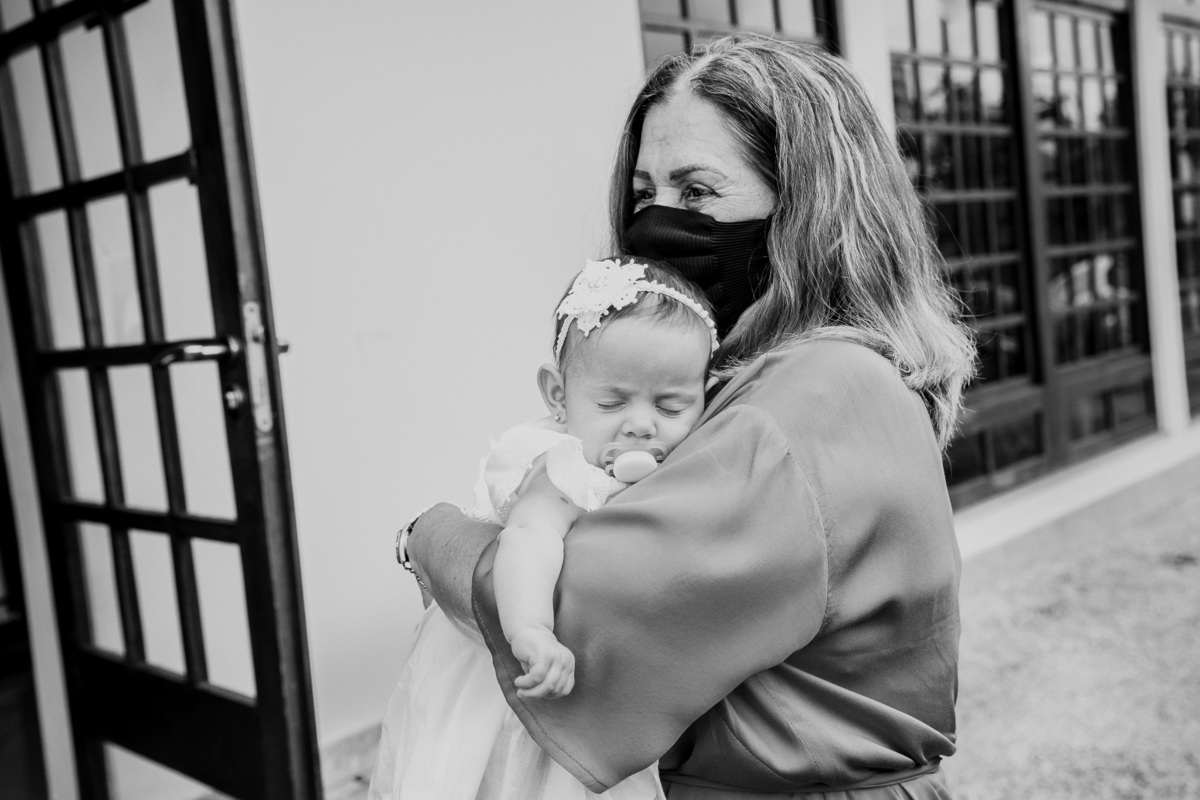 criança dorme no colo da avo na chegada do seu batizado