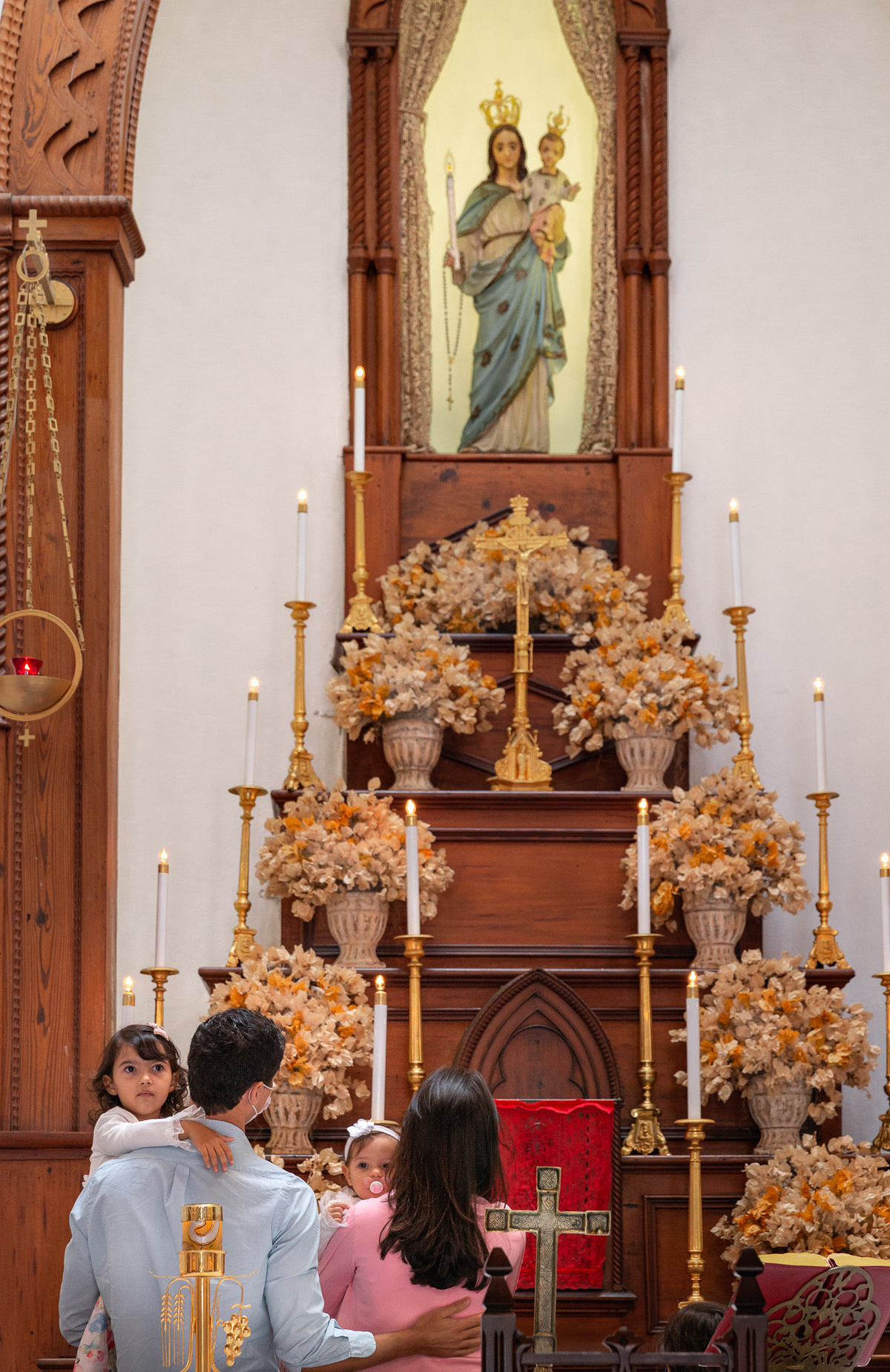 familia em frente ao altar na paroquia nossa senhora da luz apresentando sua filha a nossa senhora