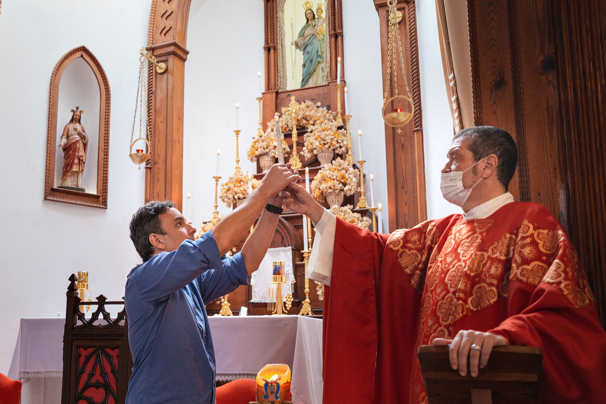 padrinho acende vela de batismo na paroquia nossa senhora da luz