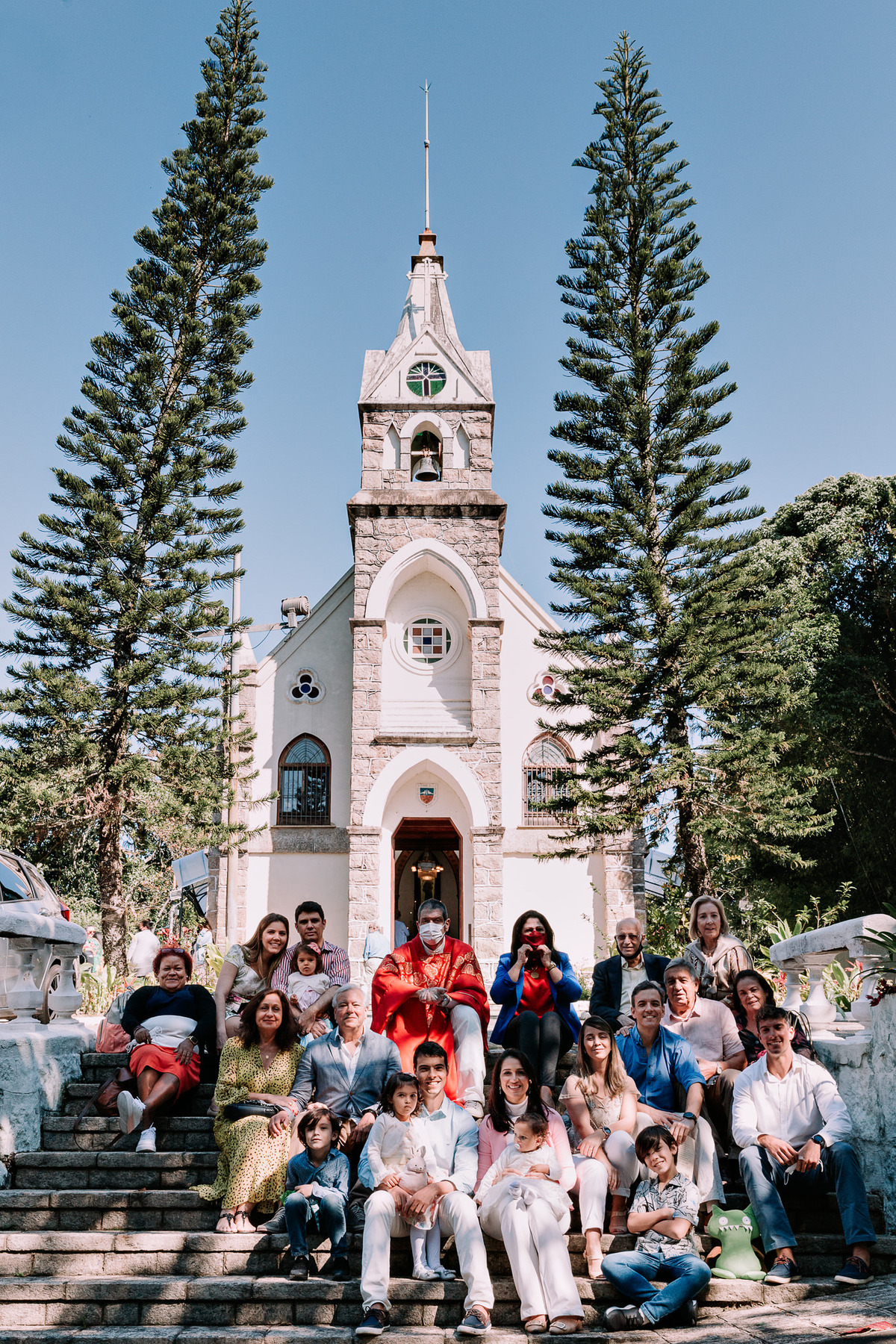 familia sentada em escada em frente a paroquia nossa senhora da luz