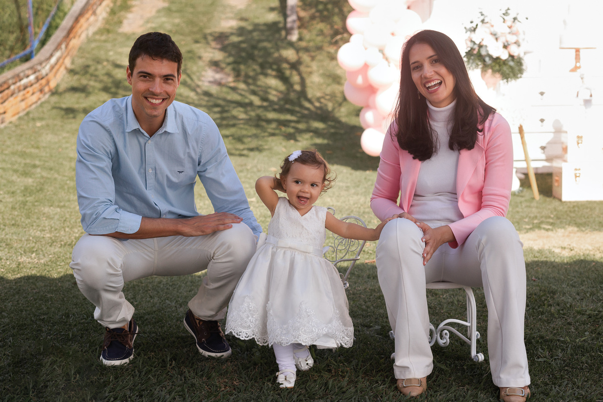 pai filha e mae agachados no chão posam para foto
