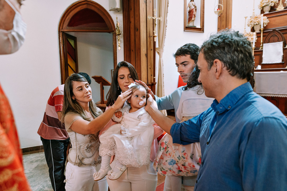 padrinhos e pais abençoam criança sendobatizada na paroquia nossa senhora da luz