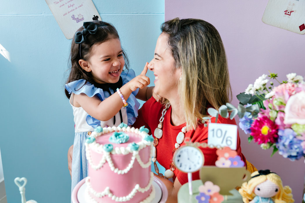 mae e filha brincam com glace de bolo no nariz na festa de aniversario com