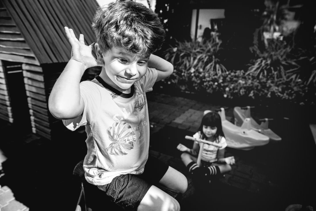 menino solta as maos de gangorra enquanto menina medita ao fundo