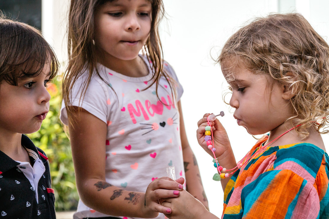 crianças assoprando bola de sabão em festa infantil