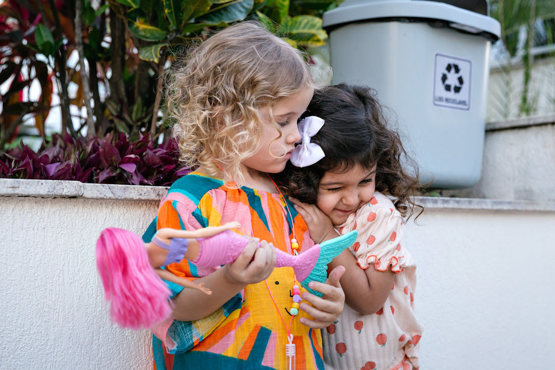 menina baraça a amiguinha equando a que é abraçada observa a atitude