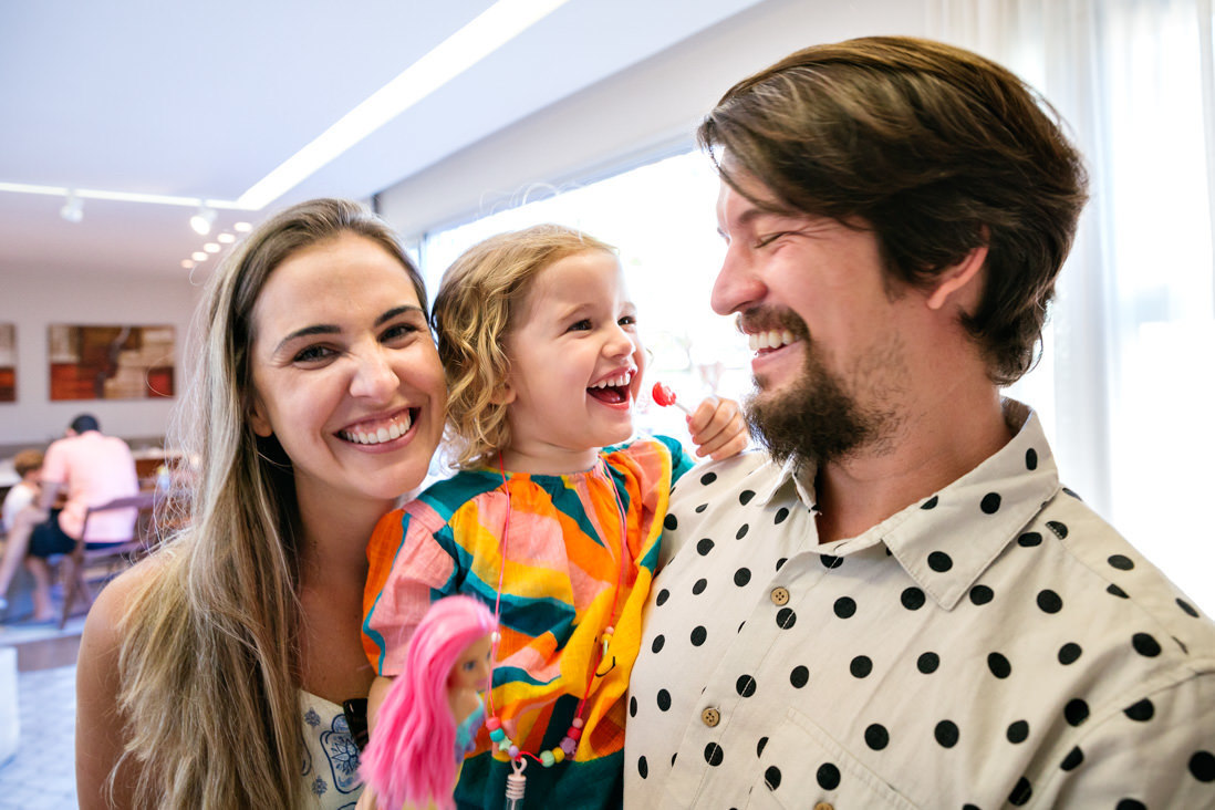 muler menina e homem sorrindo alegremente para foto em festa de aniversario infantil