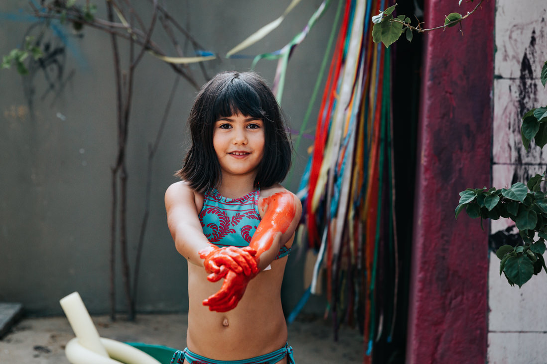 menina de biquini se pinta com tinta vermelha