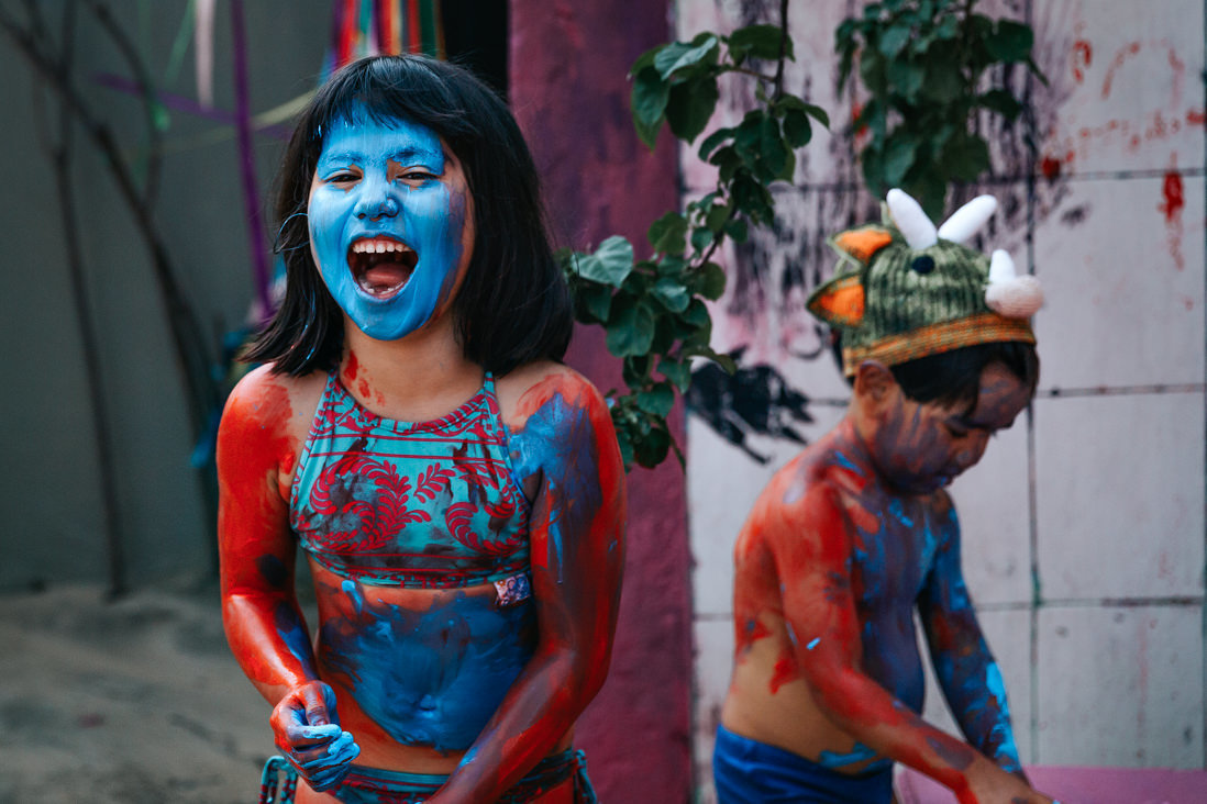 menina com rosoto azul gargalha para foto