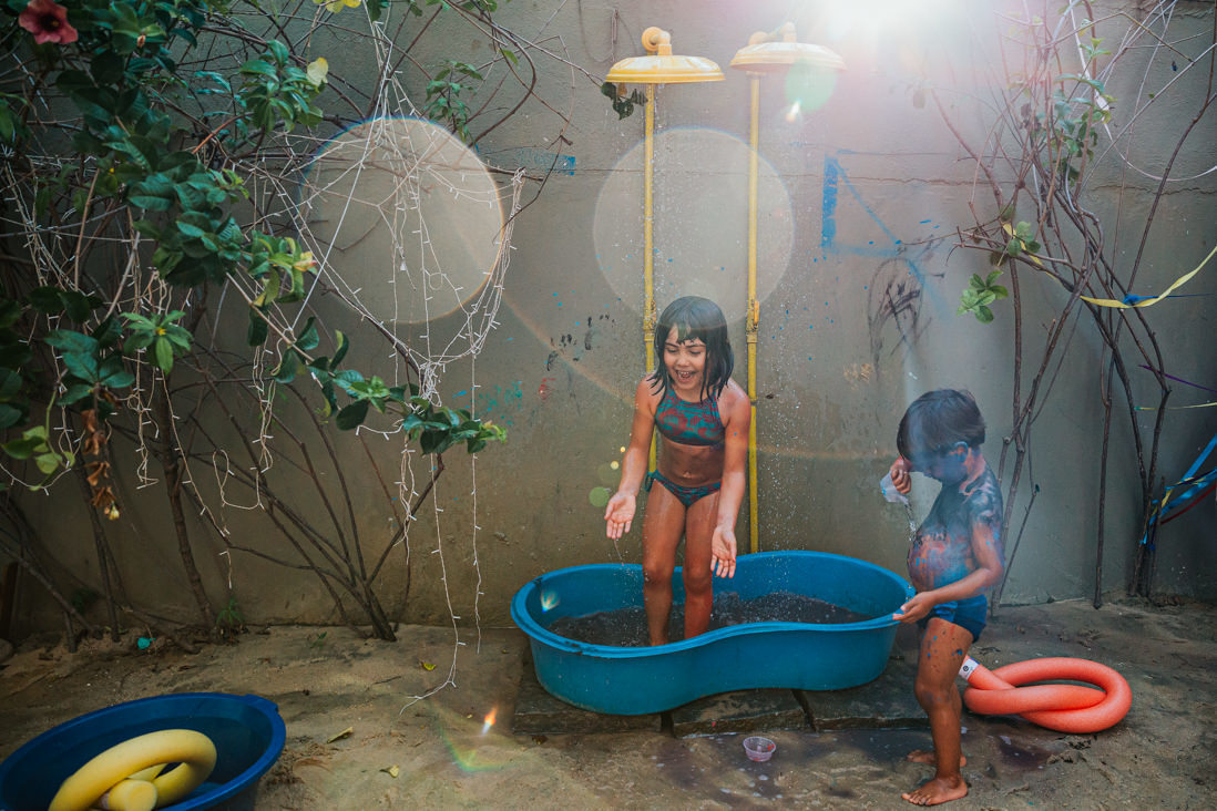 irmaos retiram tinta em chuveirao dentro de bacia grande