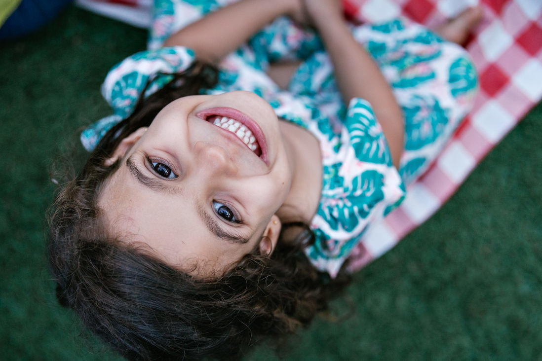 menina de 6 anos olha para o alto sentada no chao foto em plongee