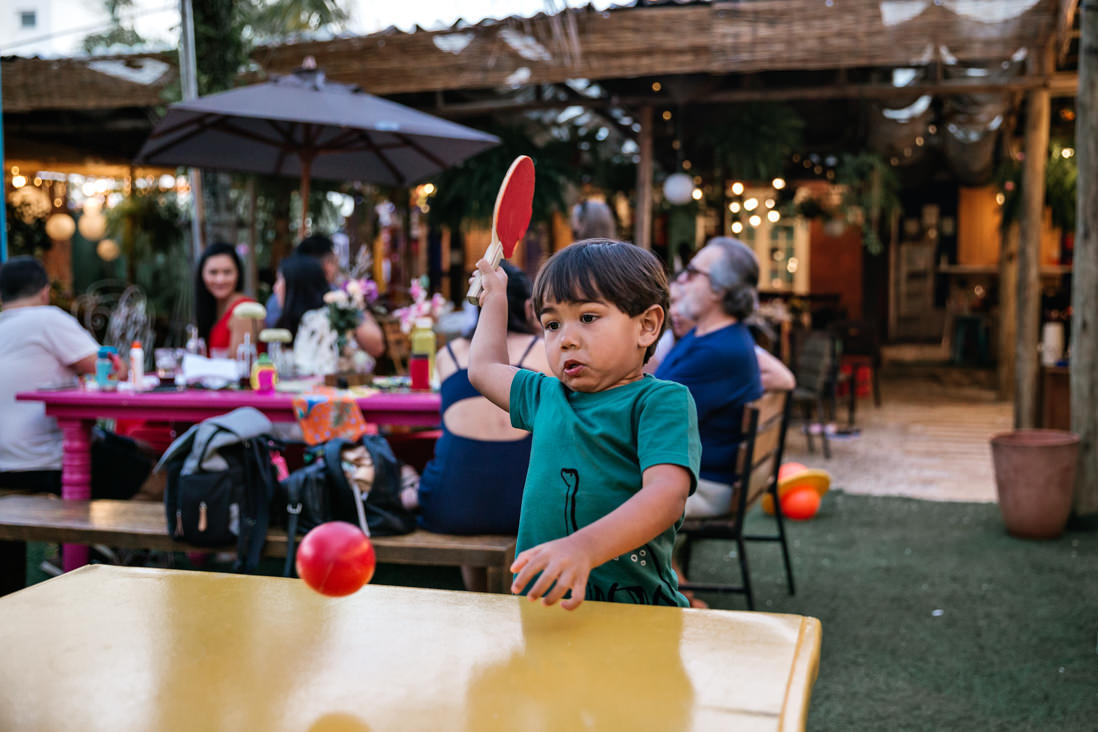 menino de 3 anos joga ping pong  fazendo movimento firme