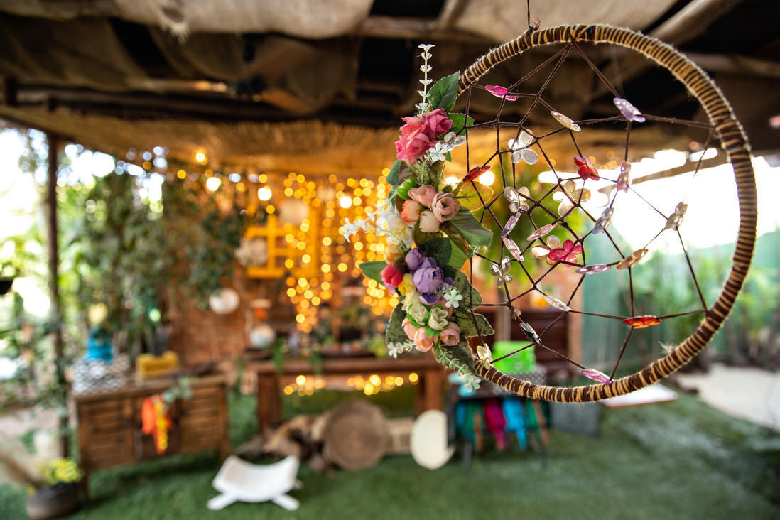 foto de filtro dos sonhos em primeiro plano e mesa de bolo dinossauros desfocada ao fundo na casa de festas O quintal no Recreio dos Bandeirantes